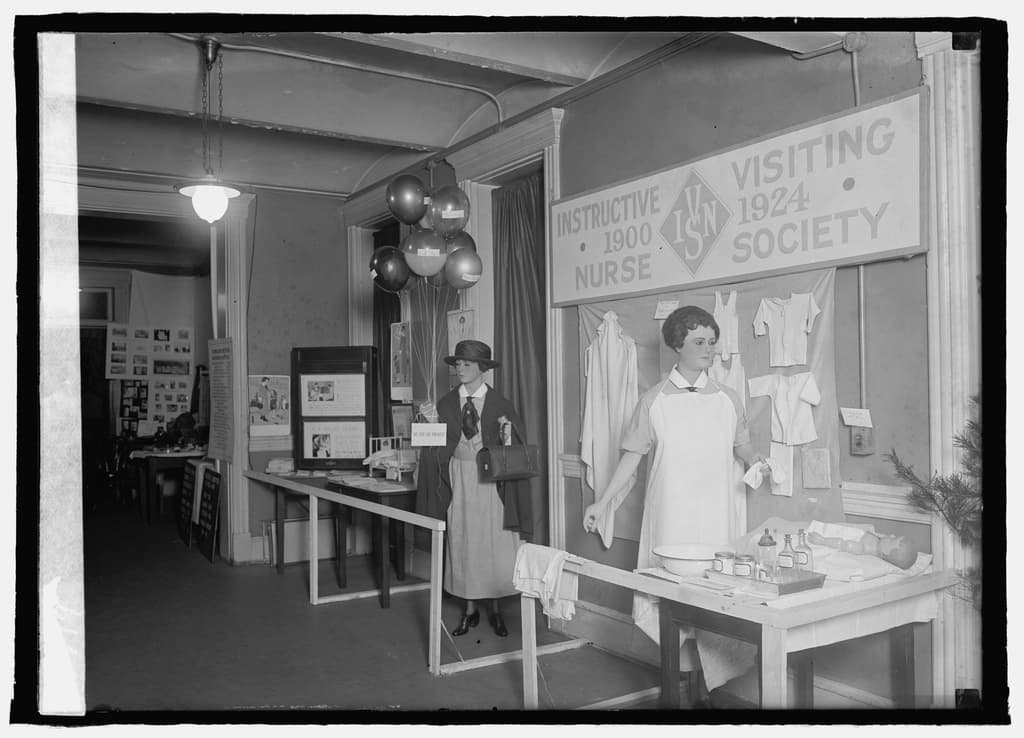 A 1920s exhibit of the Instructive Visiting Nurse Society: a nurse at a bathing table with infant clothes